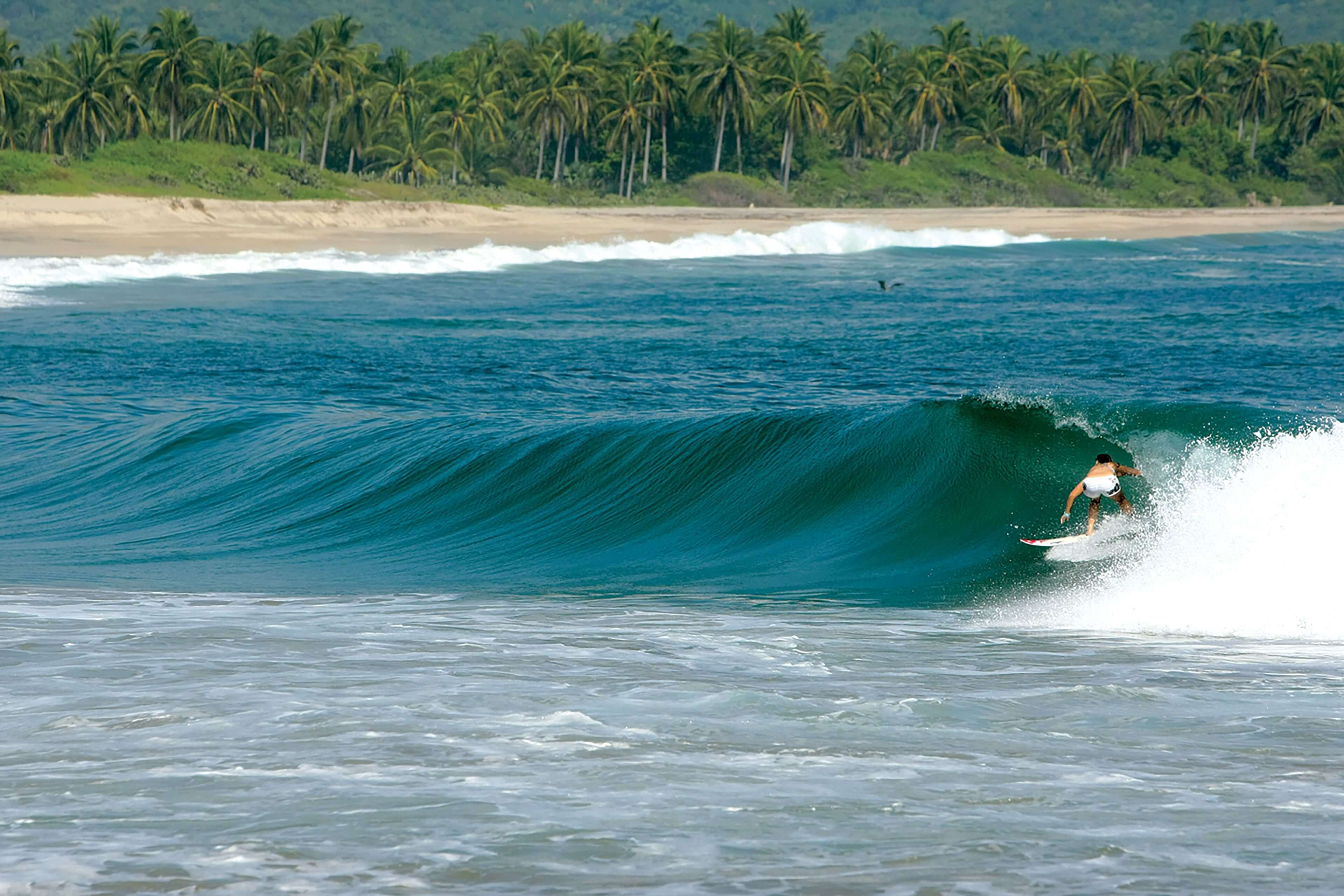 Surfer riding a wave near Chacahua